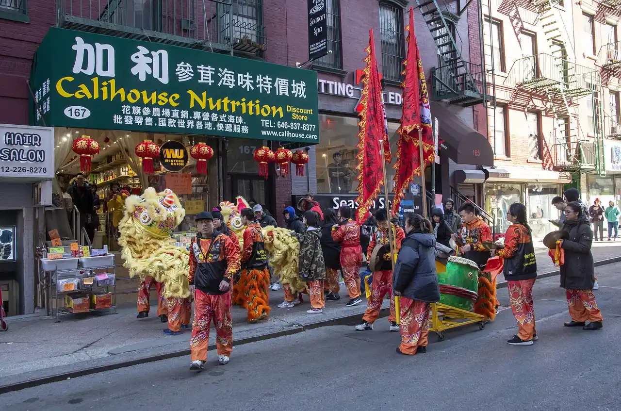 People standing outside a shop in Chinatown, New York, wearing cultural dress