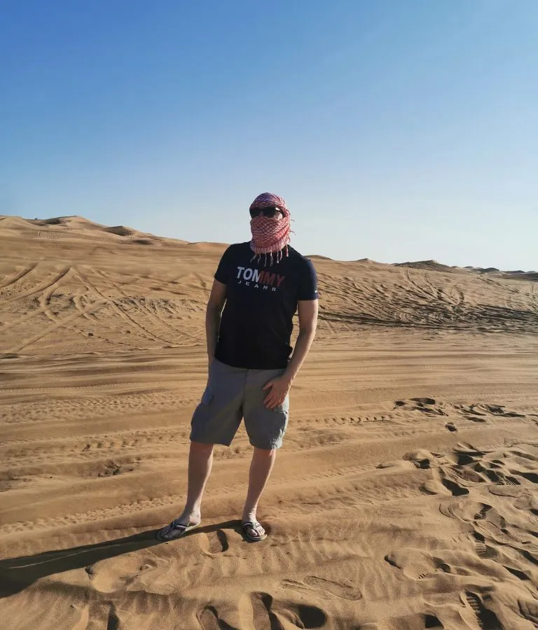 A man standing somewhere in the Desert of Dubai